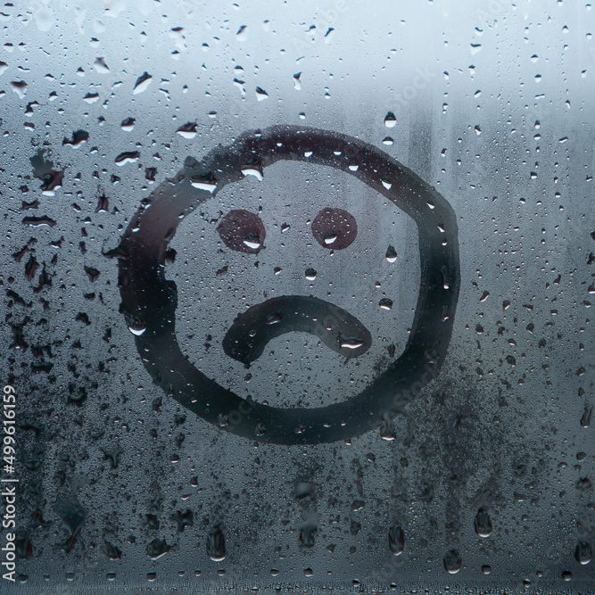 misted glass replaced by Locked solid DGR A sad face drawn on a foggy glass surface with raindrops.